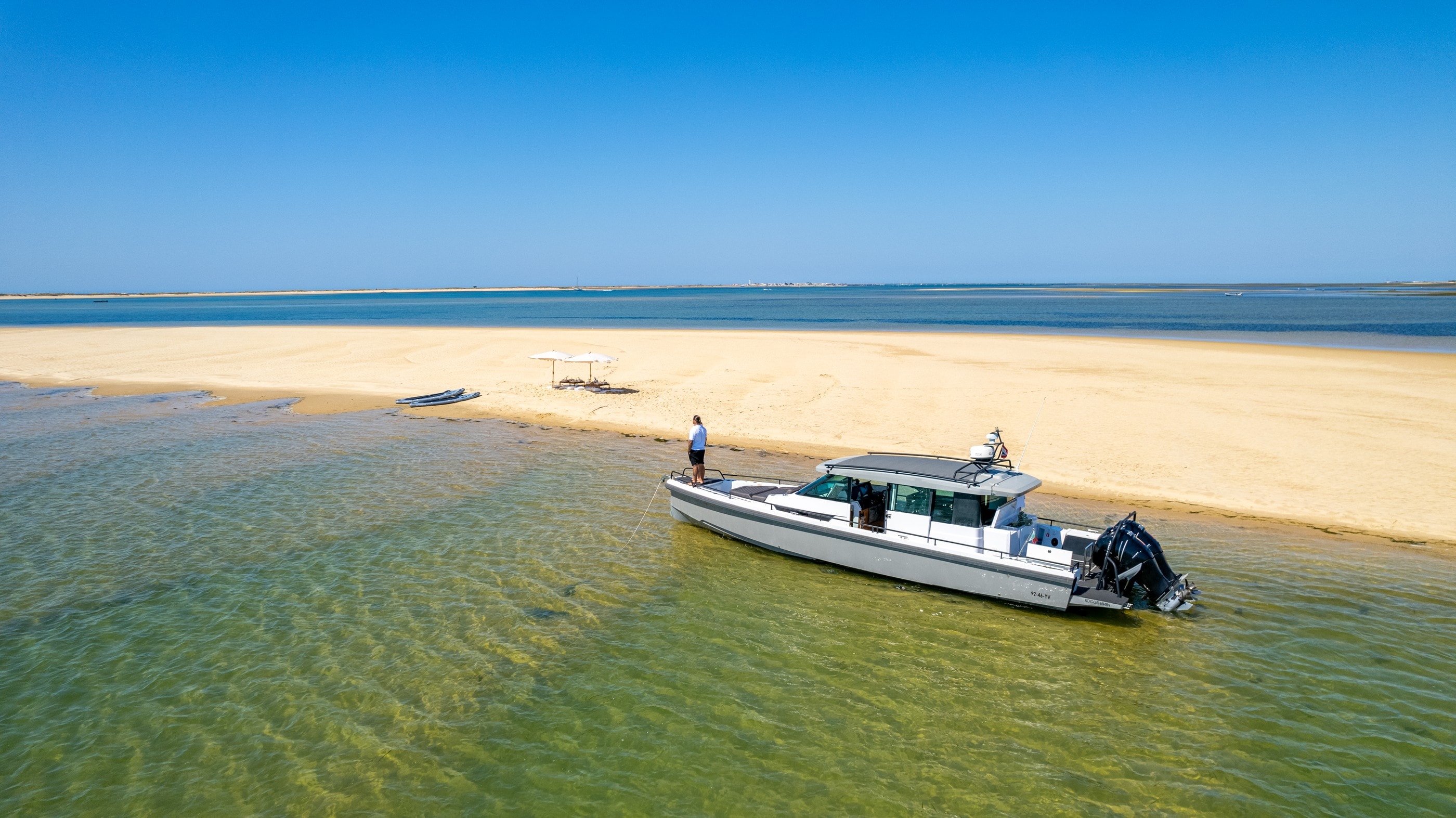 Arkeo moored beside a golden sandbank in the Ria Formosa lagoon, seen from above
